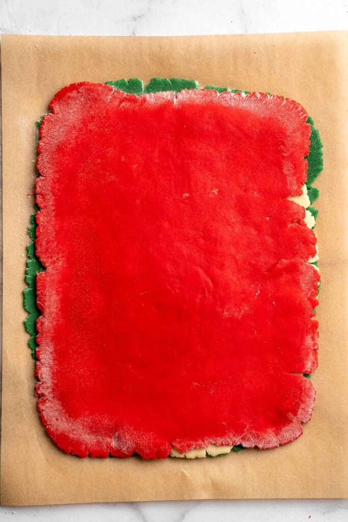 Peppermint pinwheel cookies with red, green, and white swirled dough rolled in festive sprinkles. A fun slice and bake Christmas cookie. | aheadofthyme.com