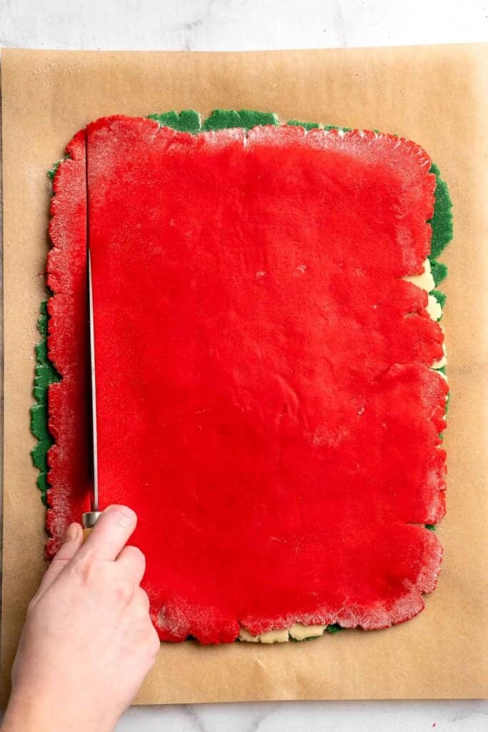 Peppermint pinwheel cookies with red, green, and white swirled dough rolled in festive sprinkles. A fun slice and bake Christmas cookie. | aheadofthyme.com