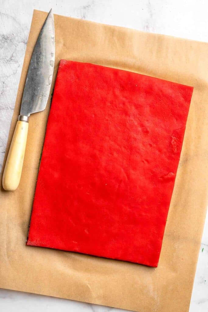 Peppermint pinwheel cookies with red, green, and white swirled dough rolled in festive sprinkles. A fun slice and bake Christmas cookie. | aheadofthyme.com