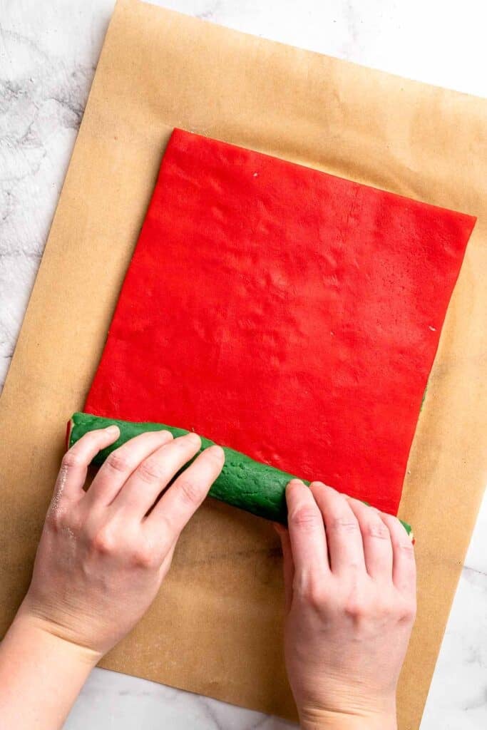 Peppermint pinwheel cookies with red, green, and white swirled dough rolled in festive sprinkles. A fun slice and bake Christmas cookie. | aheadofthyme.com