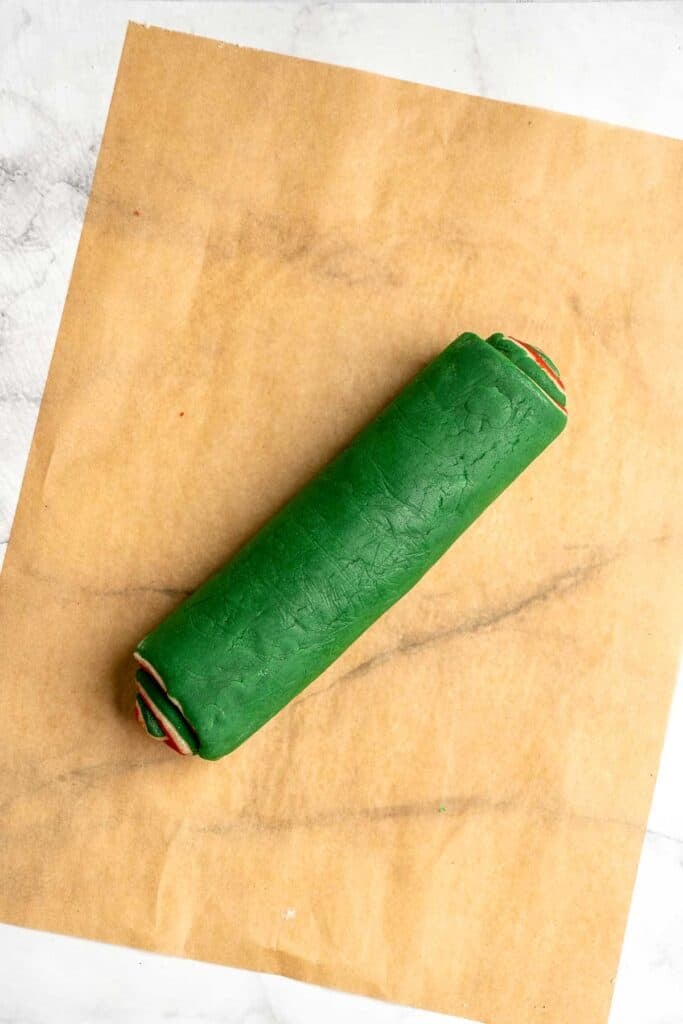 Peppermint pinwheel cookies with red, green, and white swirled dough rolled in festive sprinkles. A fun slice and bake Christmas cookie. | aheadofthyme.com