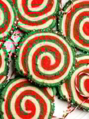 Peppermint pinwheel cookies with red, green, and white swirled dough rolled in festive sprinkles. A fun slice and bake Christmas cookie. | aheadofthyme.com