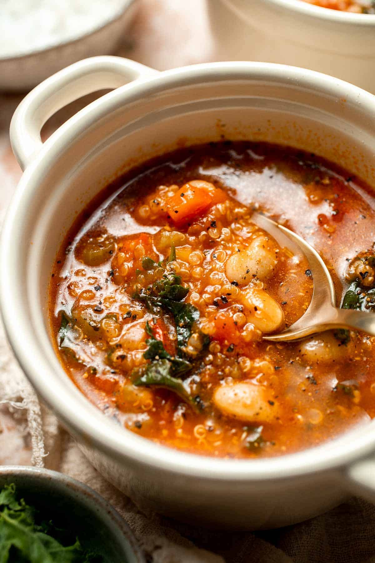 Hearty quinoa vegetable soup with tomatoes, beans, and kale. Healthy, cozy, and easy to make in one pot for a nourishing meal. | aheadofthyme.com