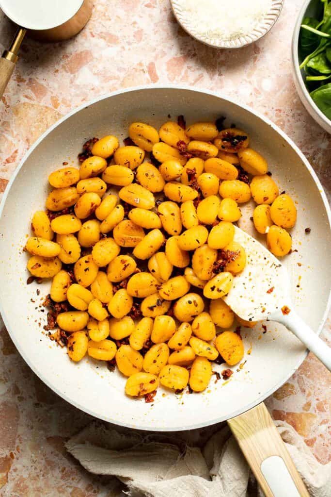 This creamy Tuscan gnocchi is a quick one pan dinner with sun dried tomatoes, spinach, garlic, and Parmesan. | aheadofthyme.com