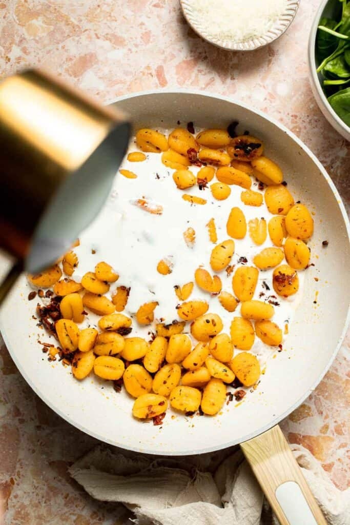 This creamy Tuscan gnocchi is a quick one pan dinner with sun dried tomatoes, spinach, garlic, and Parmesan. | aheadofthyme.com