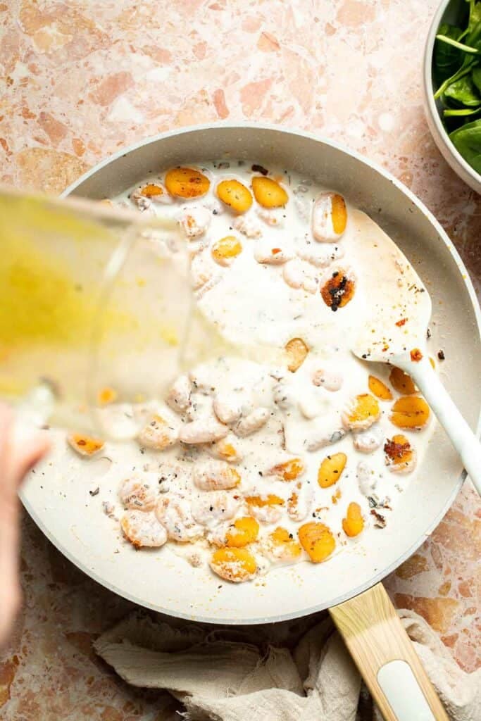 This creamy Tuscan gnocchi is a quick one pan dinner with sun dried tomatoes, spinach, garlic, and Parmesan. | aheadofthyme.com