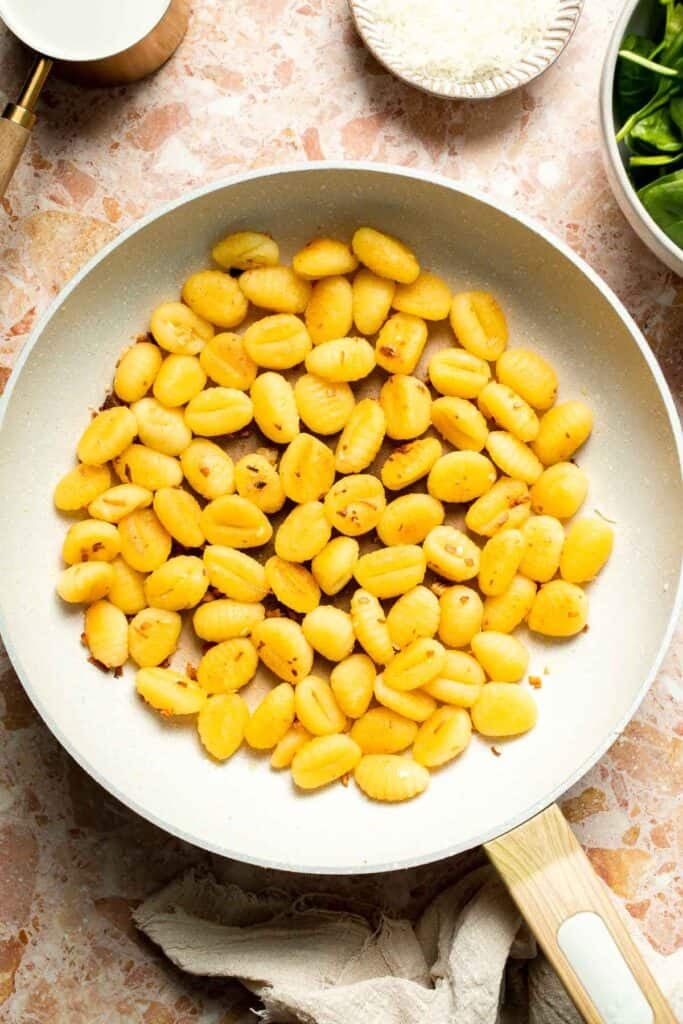 This creamy Tuscan gnocchi is a quick one pan dinner with sun dried tomatoes, spinach, garlic, and Parmesan. | aheadofthyme.com