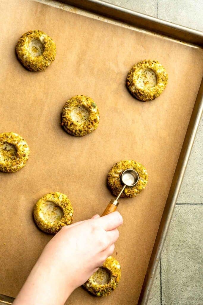 Buttery pistachio thumbprint cookies filled with pistachio white chocolate ganache that bake into elegant, nutty treats perfect for gifting or any occasion. | aheadofthyme.com