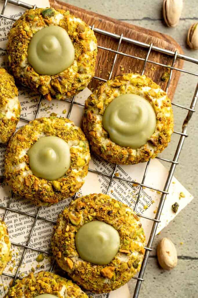 Buttery pistachio thumbprint cookies filled with pistachio white chocolate ganache that bake into elegant, nutty treats perfect for gifting or any occasion. | aheadofthyme.com