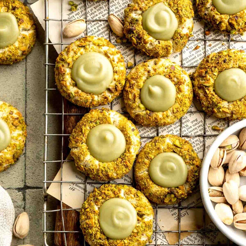 Buttery pistachio thumbprint cookies filled with pistachio white chocolate ganache that bake into elegant, nutty treats perfect for gifting or any occasion. | aheadofthyme.com