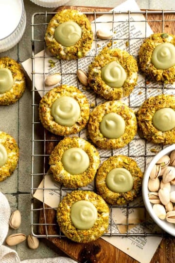 Buttery pistachio thumbprint cookies filled with pistachio white chocolate ganache that bake into elegant, nutty treats perfect for gifting or any occasion. | aheadofthyme.com