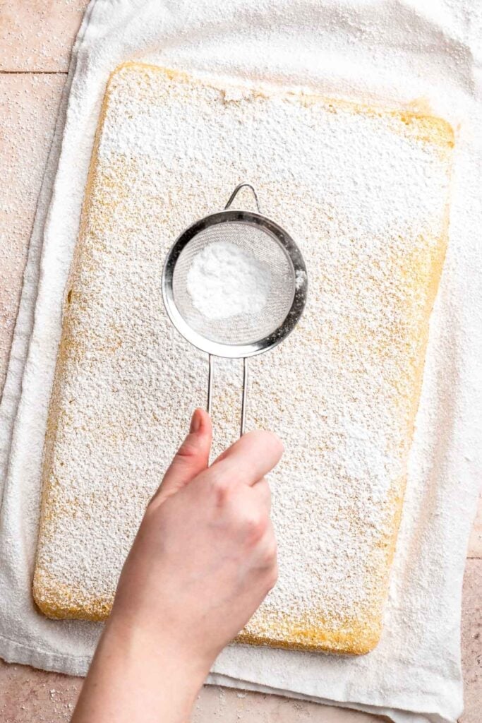 Light and fluffy vanilla Swiss roll cake filled with whipped cream, made with a soft sponge that rolls beautifully every time. | aheadofthyme.com