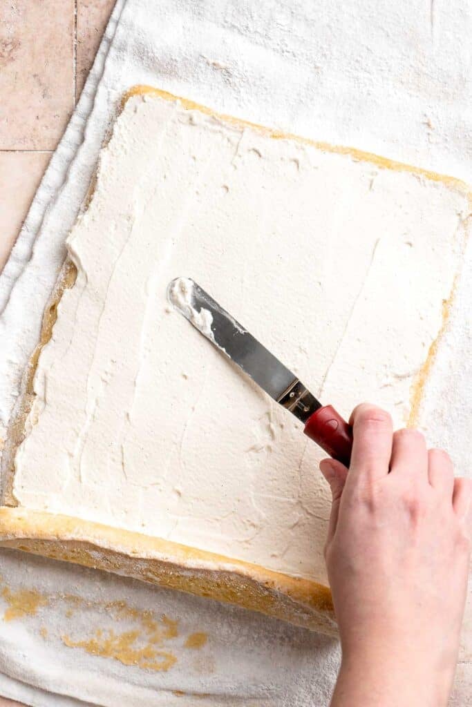 Light and fluffy vanilla Swiss roll cake filled with whipped cream, made with a soft sponge that rolls beautifully every time. | aheadofthyme.com