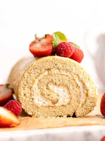 Light and fluffy vanilla Swiss roll cake filled with whipped cream, made with a soft sponge that rolls beautifully every time. | aheadofthyme.com