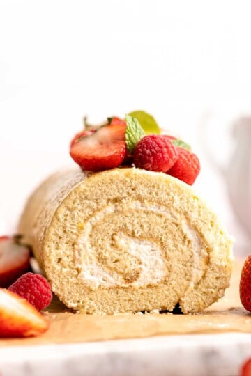 Light and fluffy vanilla Swiss roll cake filled with whipped cream, made with a soft sponge that rolls beautifully every time. | aheadofthyme.com