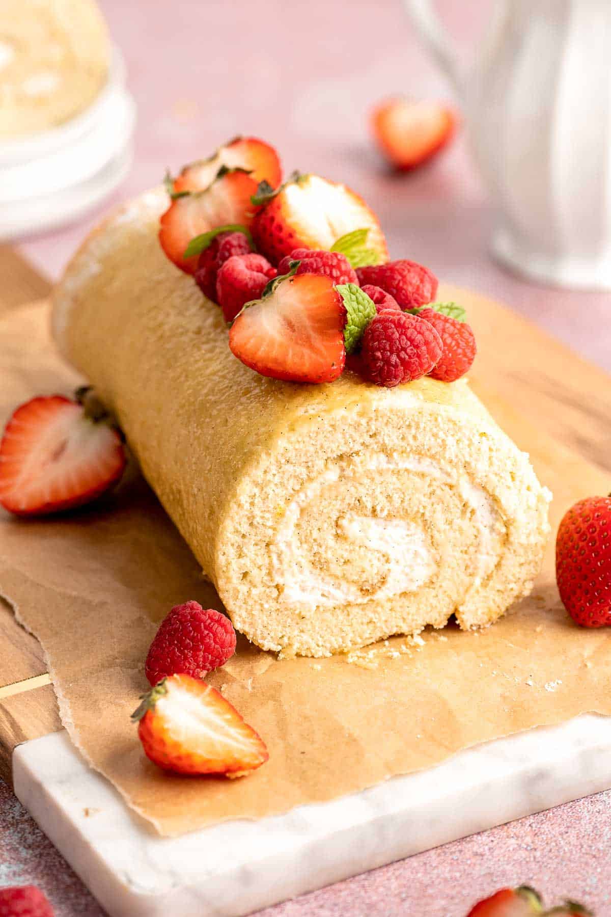 Light and fluffy vanilla Swiss roll cake filled with whipped cream, made with a soft sponge that rolls beautifully every time. | aheadofthyme.com
