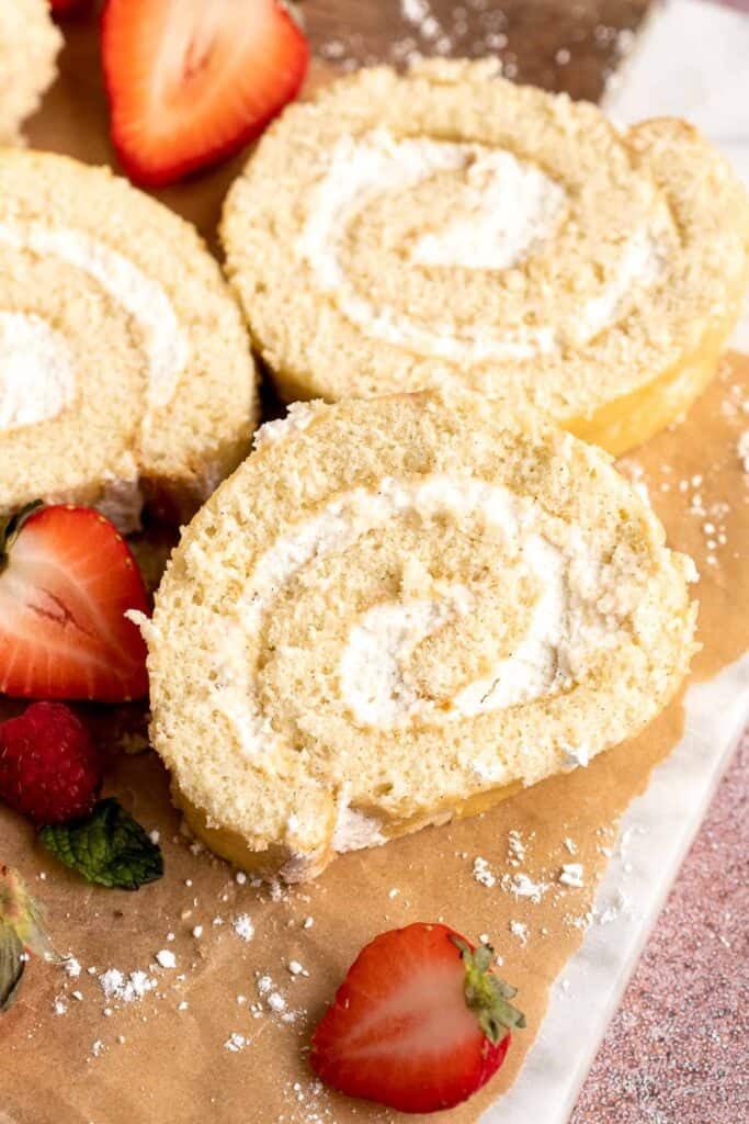 Light and fluffy vanilla Swiss roll cake filled with whipped cream, made with a soft sponge that rolls beautifully every time. | aheadofthyme.com
