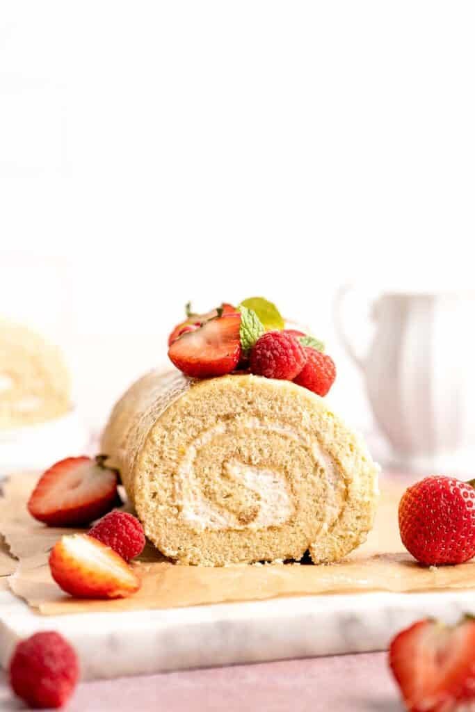 Light and fluffy vanilla Swiss roll cake filled with whipped cream, made with a soft sponge that rolls beautifully every time. | aheadofthyme.com