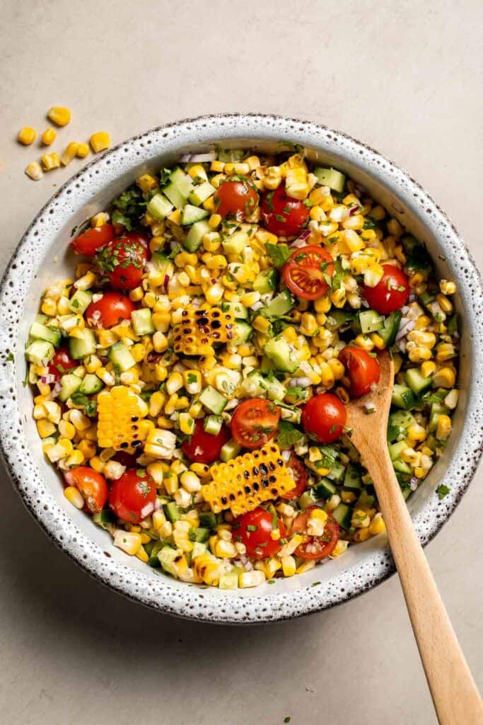 Avocado corn salad tossed together in a large bowl.