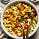 Avocado corn salad with grilled corn, avocado, cherry tomatoes, cucumber, red onion, cilantro, and lime dressing.