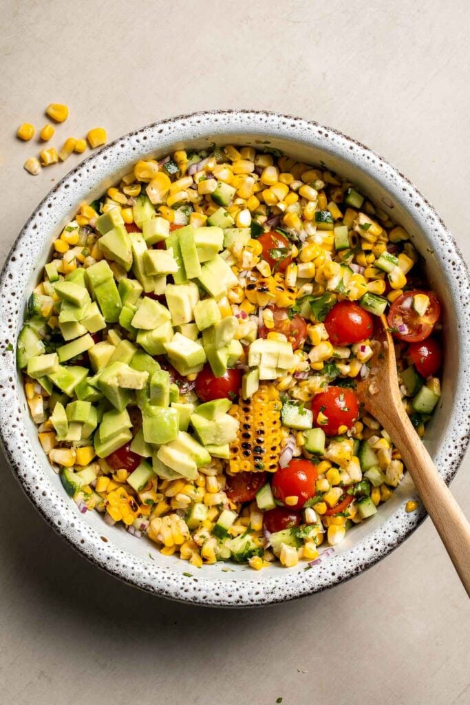 Diced avocado added to avocado corn salad.