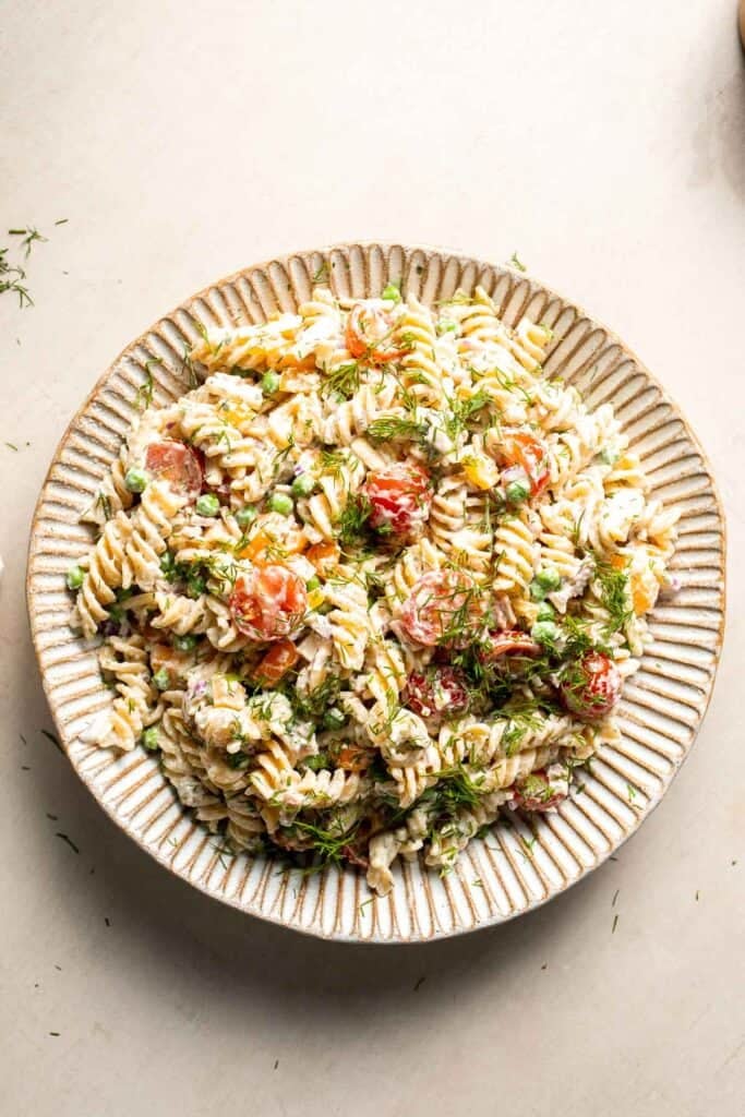 Bacon ranch pasta salad garnished with fresh herbs and ready to serve.