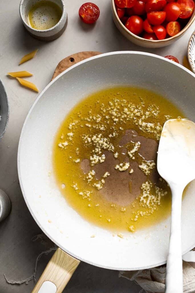 Garlic sautéing in olive oil until fragrant.