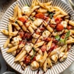 Caprese pasta with fresh mozzarella, cherry tomatoes, basil, Parmesan cheese, and balsamic glaze. Easy tomato mozzarella pasta recipe.