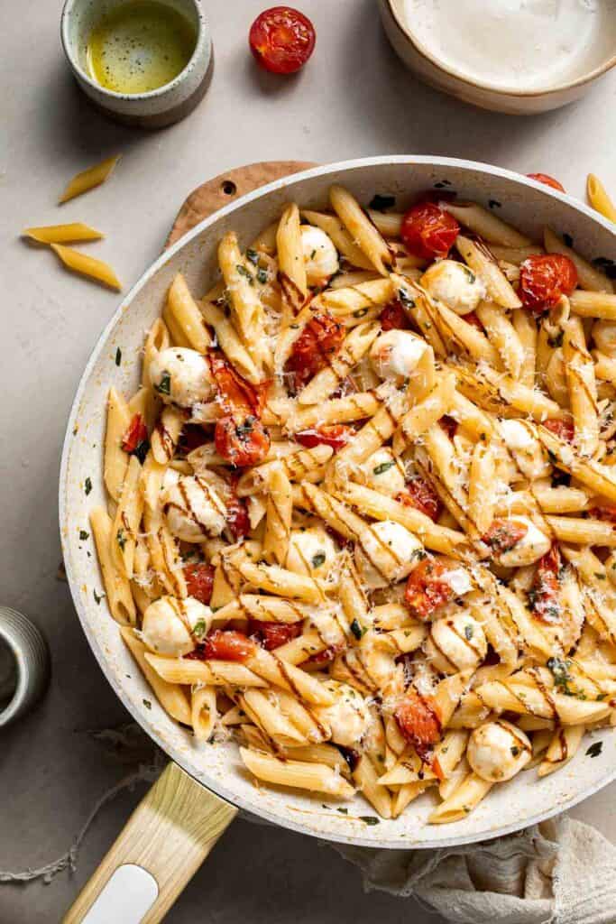 Caprese pasta with cherry tomatoes, mozzarella, basil, and Parmesan cheese.