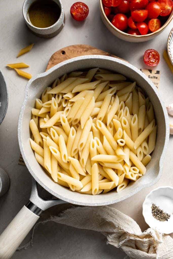 Penne pasta cooking in boiling water until al dente.