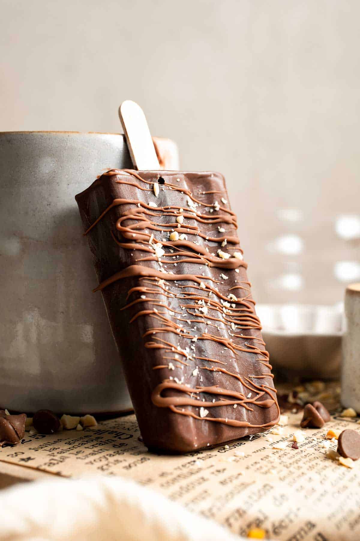 Close-up of a homemade fudgesicle topped with chocolate drizzle.