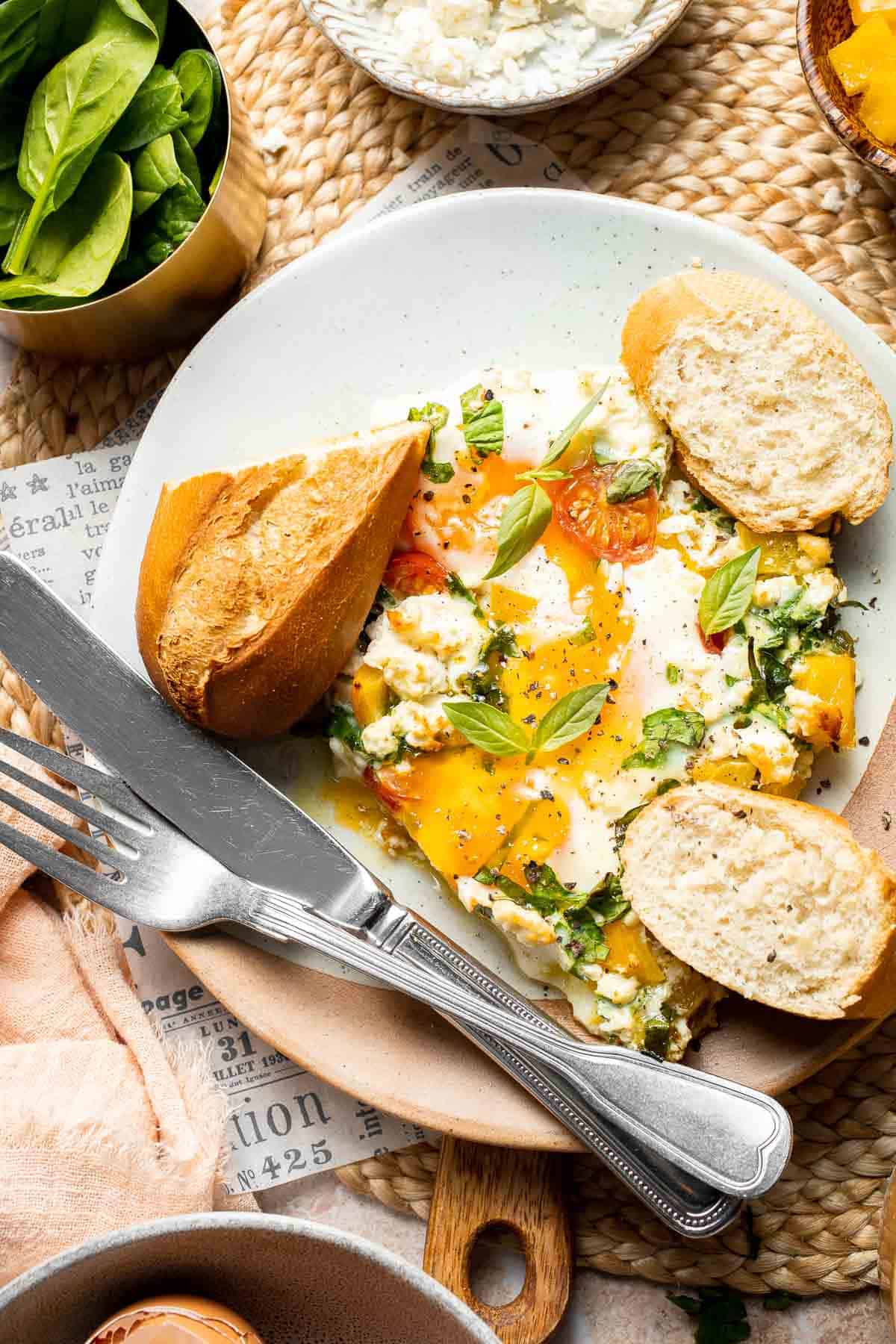 Mediterranean baked eggs with feta and tomatoes served with crusty toast.