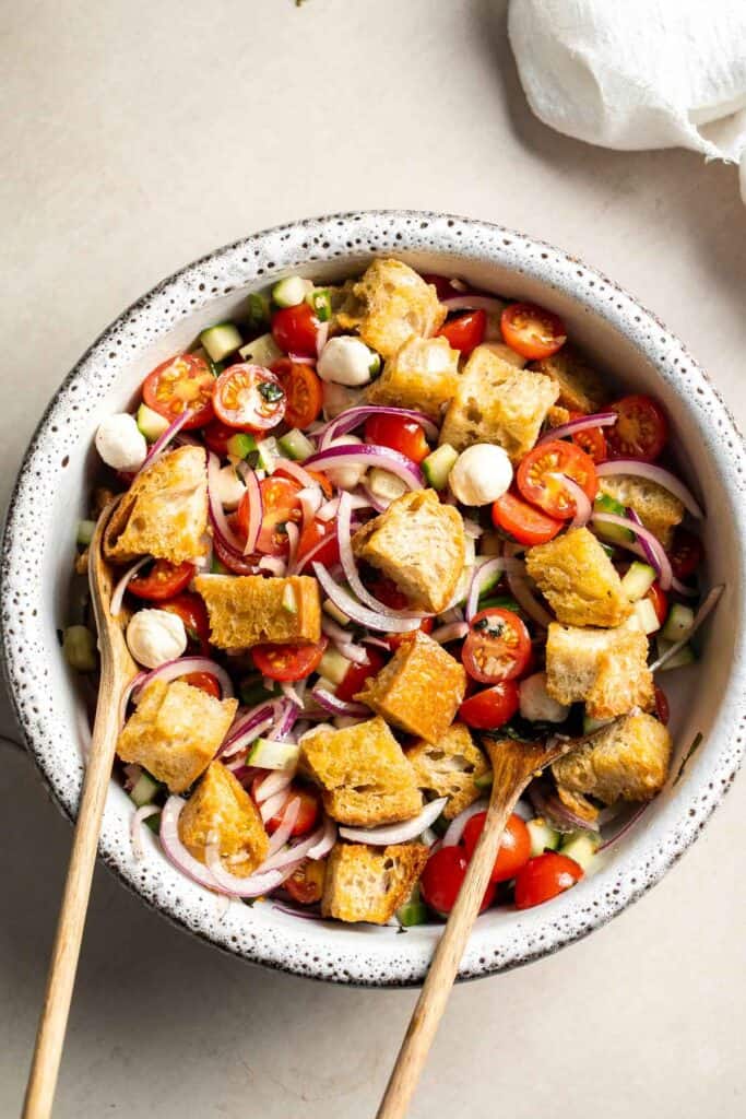 Ingredients for panzanella salad arranged in a serving bowl before tossing