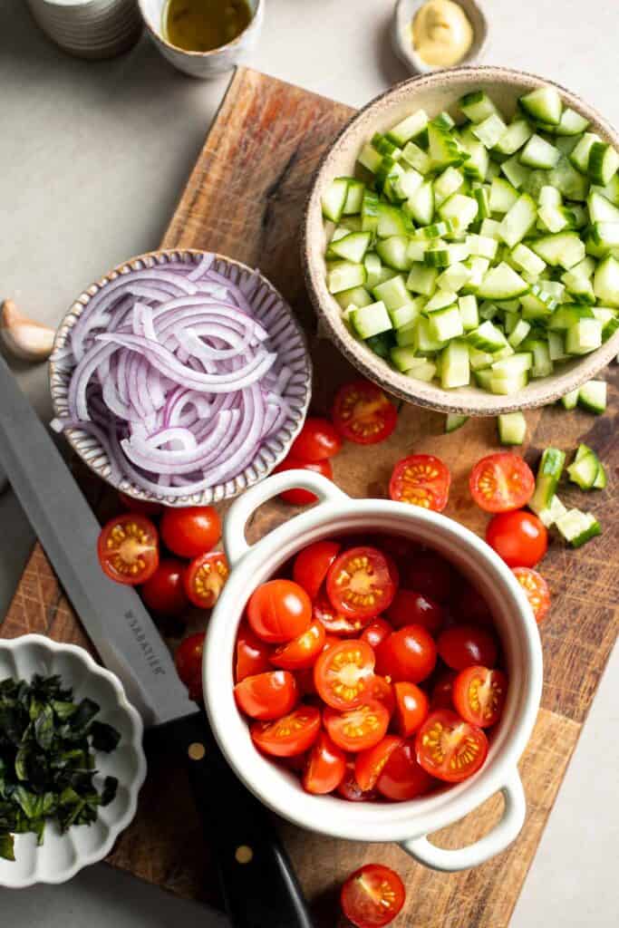 Chopped cucumber, red onion, tomatoes, and basil for panzanella salad