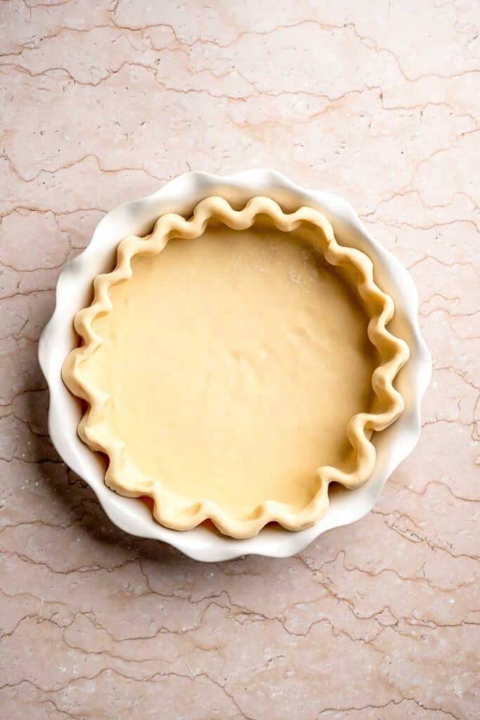 Prepared pie crust with crimped edges ready to fill.