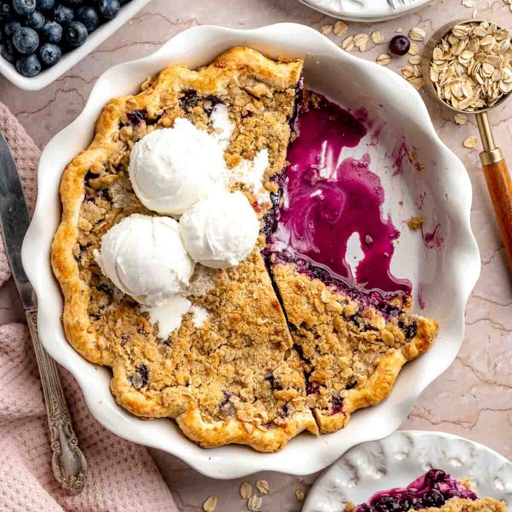 Blueberry Crumble Pie with juicy blueberry filling, a buttery oat crumble topping, and vanilla ice cream.