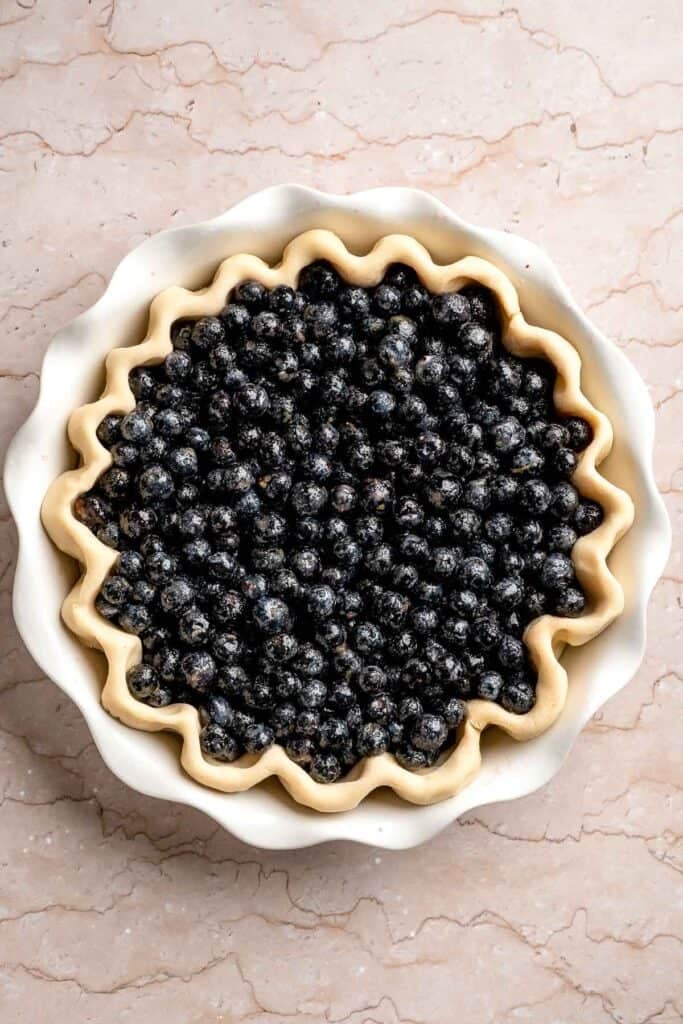Blueberry pie filling added to the prepared pie crust.