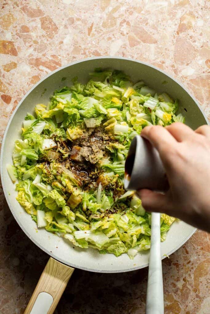 Soy sauce being added to cabbage while making Chinese Cabbage Stir Fry.