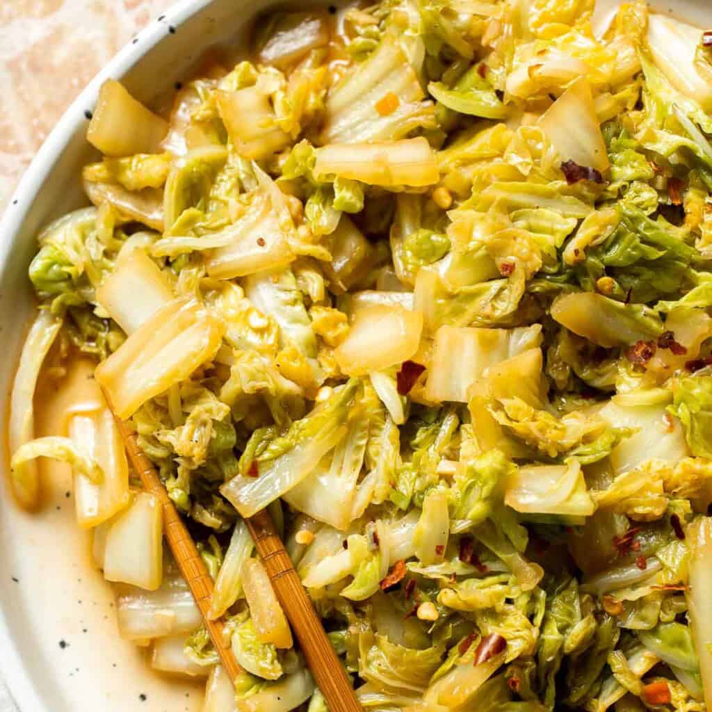 Chinese Cabbage Stir Fry served in a plate with garlic, soy sauce, and sesame seeds.