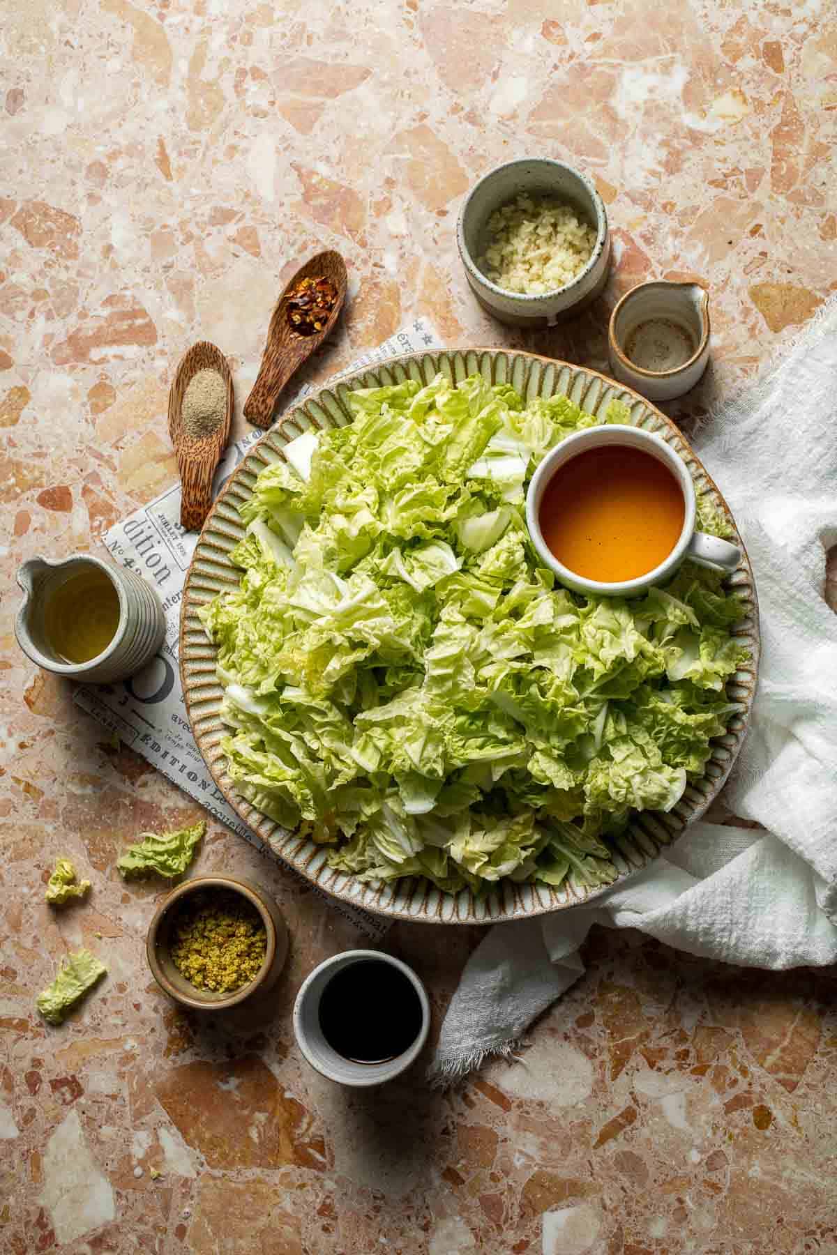 Ingredients for Chinese Cabbage Stir Fry including chopped Napa cabbage, garlic, soy sauce, sesame oil, and seasonings.