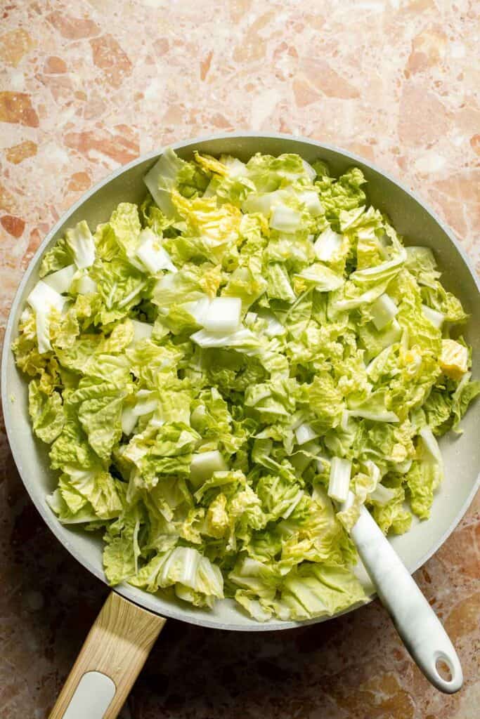 Chopped Napa cabbage added to a skillet for Chinese Cabbage Stir Fry.