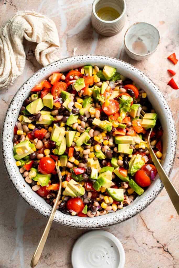 Gently folding avocado into homemade Cowboy Caviar.