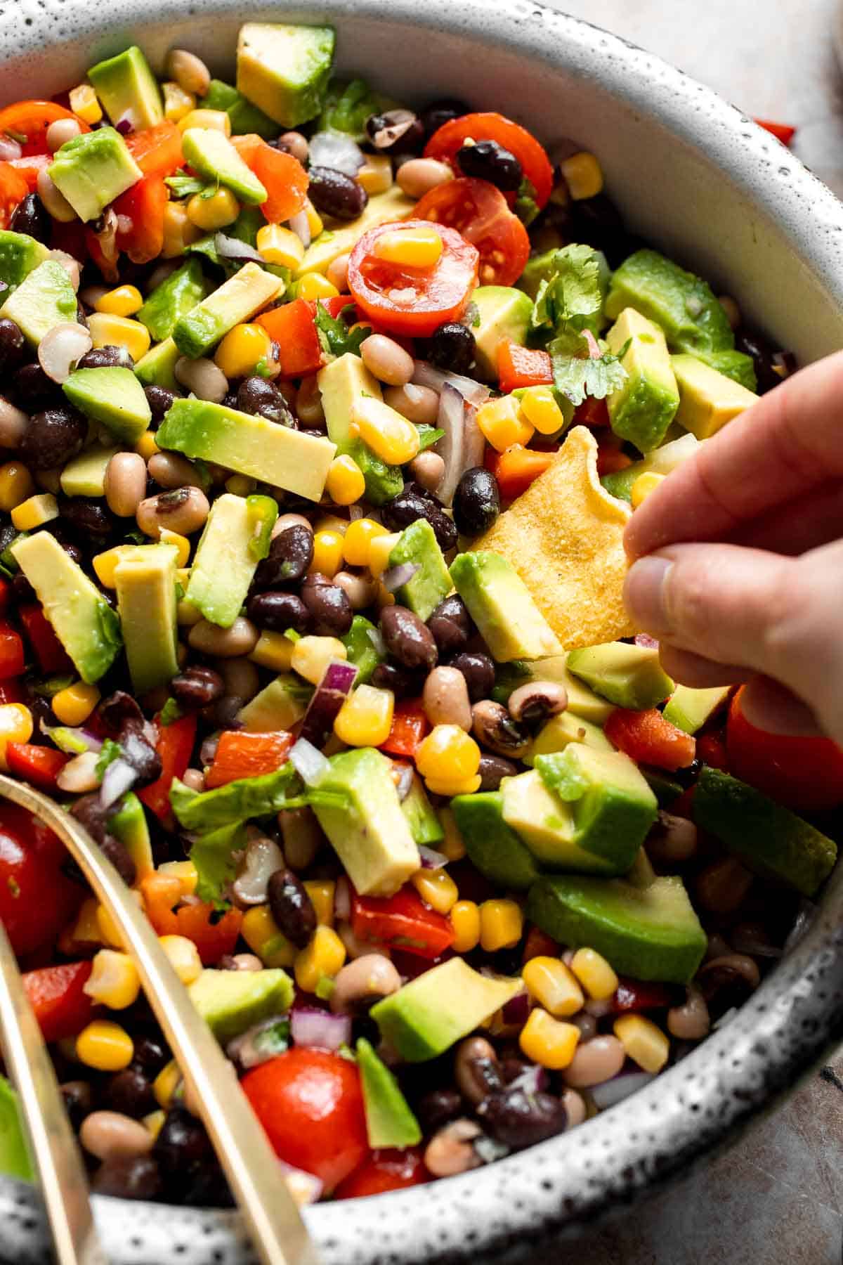 Close-up of Cowboy Caviar with black beans, corn, avocado, tomatoes, and fresh cilantro.