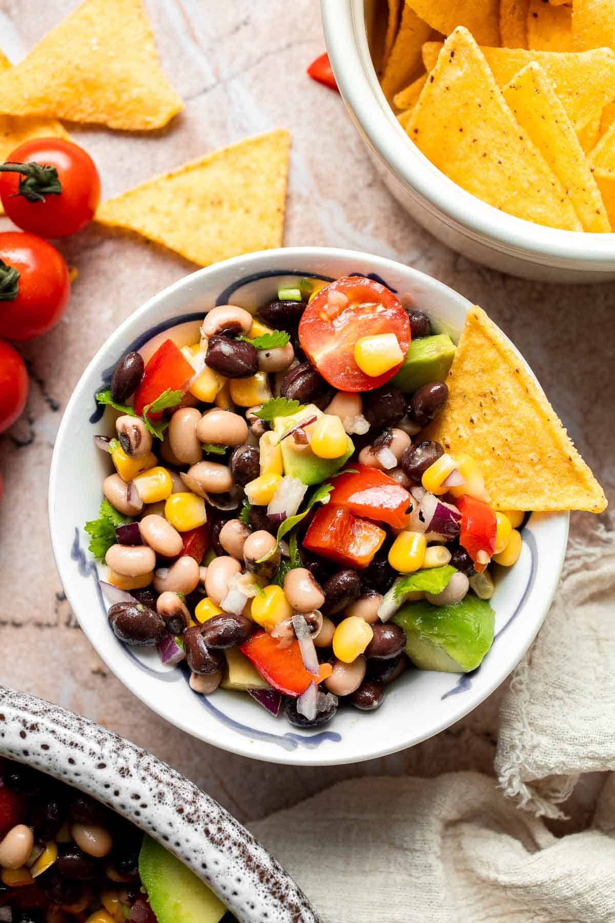 Bowl of Cowboy Caviar served with tortilla chips for dipping.