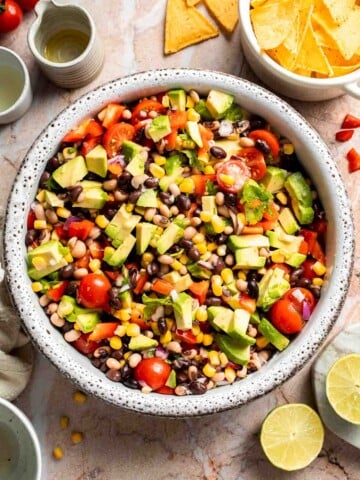 Fresh Cowboy Caviar made with black beans, black-eyed peas, corn, avocado, tomatoes, and a zesty lime dressing.