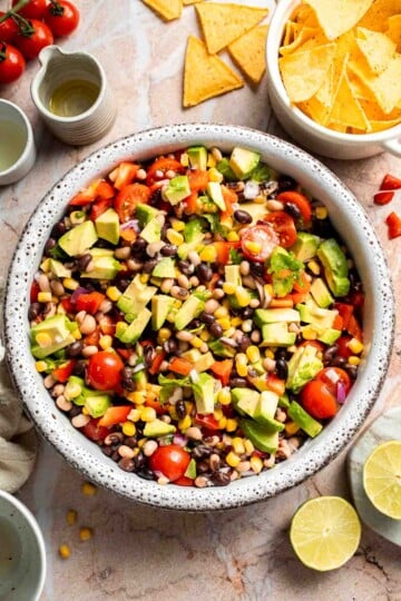 Fresh Cowboy Caviar made with black beans, black-eyed peas, corn, avocado, tomatoes, and a zesty lime dressing.