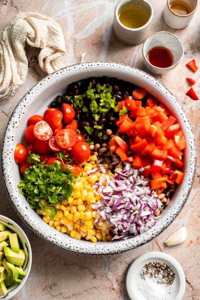 Ingredients for Cowboy Caviar combined in a large mixing bowl before tossing with dressing.