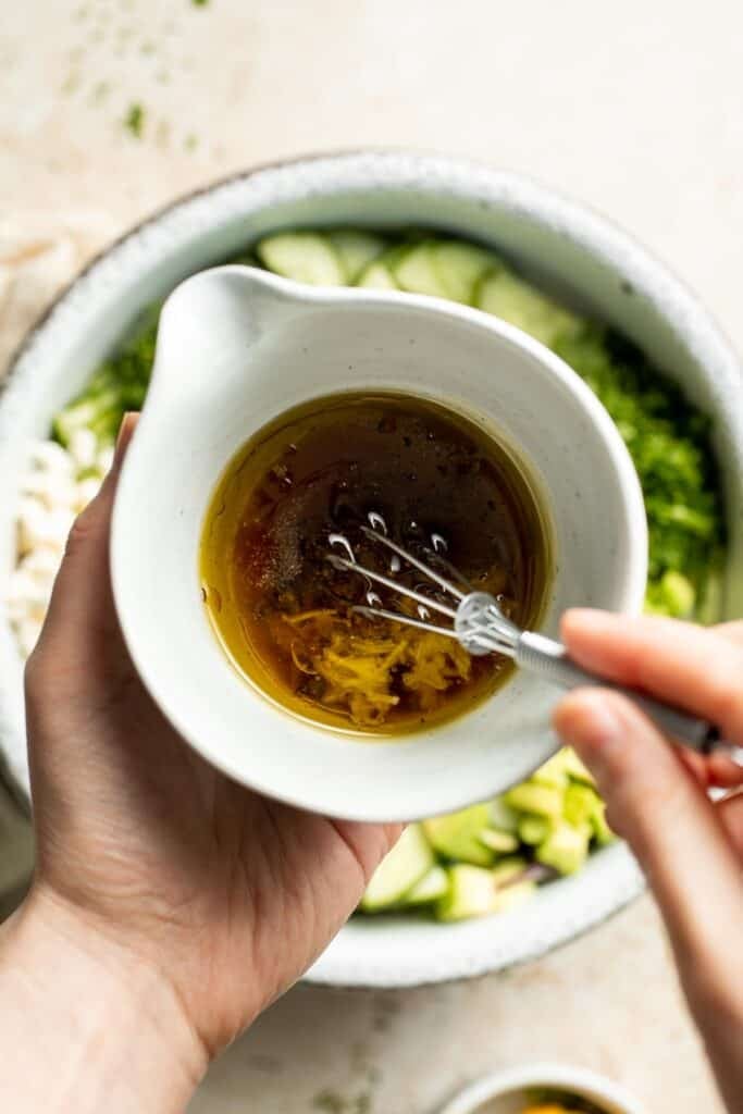 Whisking the lemon vinaigrette for cucumber feta salad.
