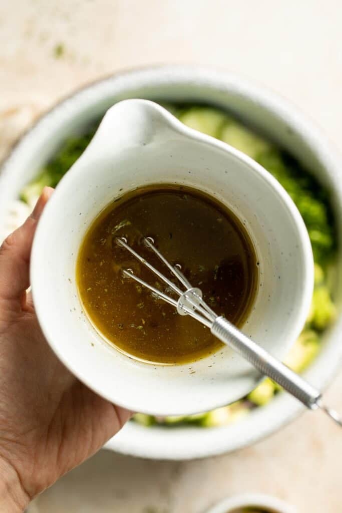 Homemade lemon vinaigrette with garlic and oregano for cucumber feta salad.