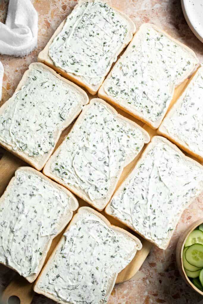 White bread slices topped with creamy dill and chive cream cheese spread.